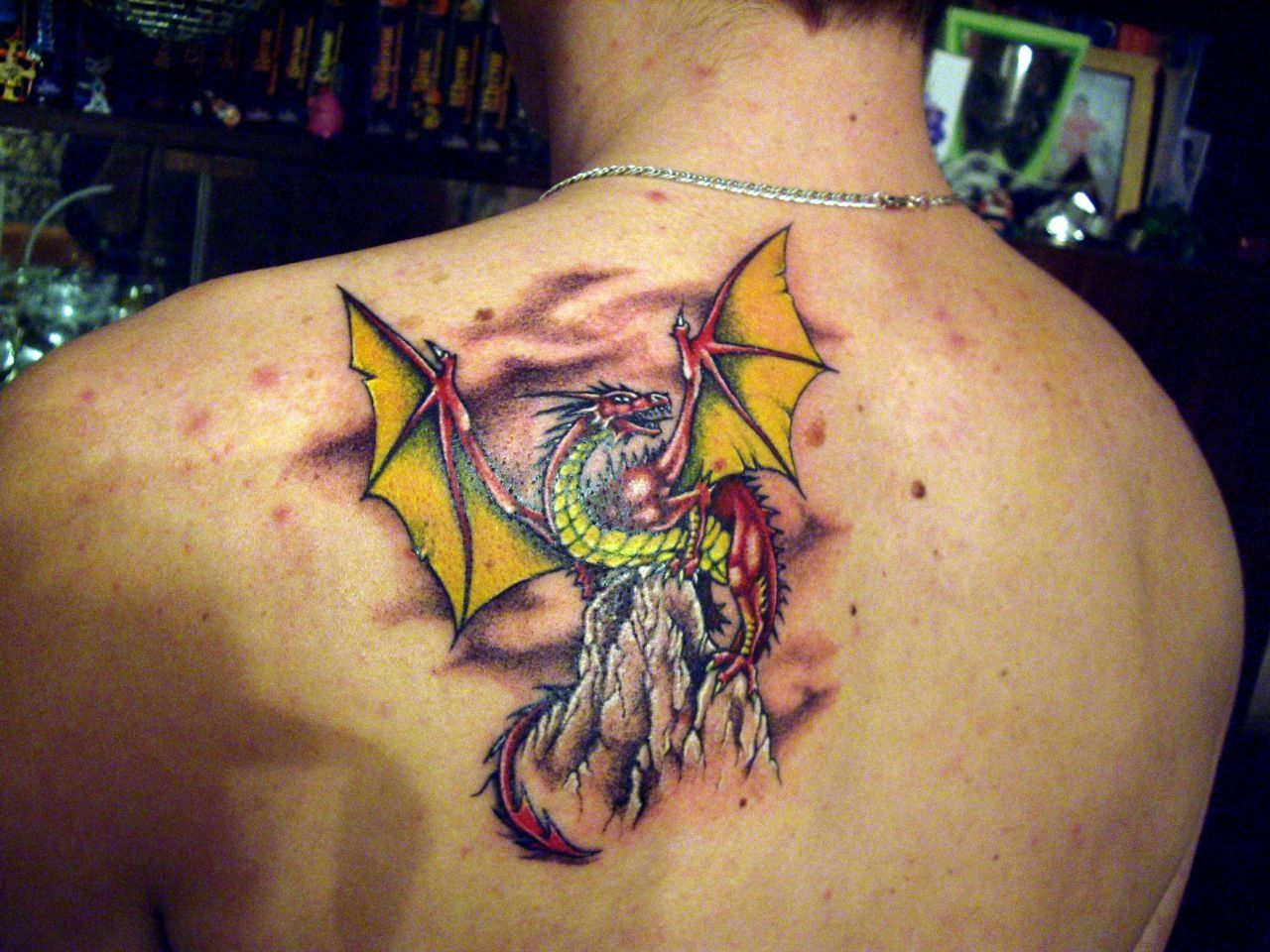 Awesome Dragon With Yellow Wings Which Sits On A Rock Tattoo On with regard to dimensions 1280 X 960