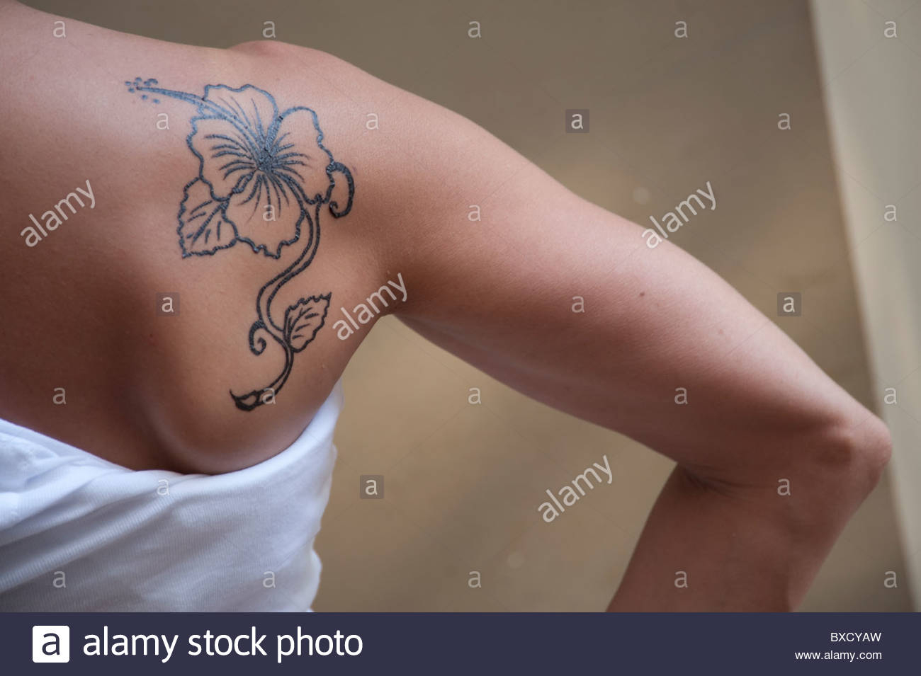 Hibiscus Flower Tattoo On The Shoulder Of A Young Woman In A White in proportions 1300 X 955