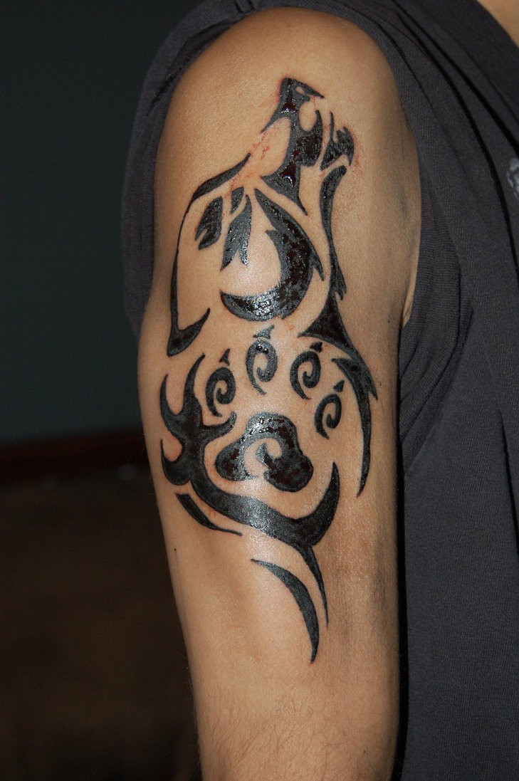Tribal Style Black Ink Shoulder Tattoo Of Wolf Tattooimagesbiz pertaining to measurements 729 X 1097